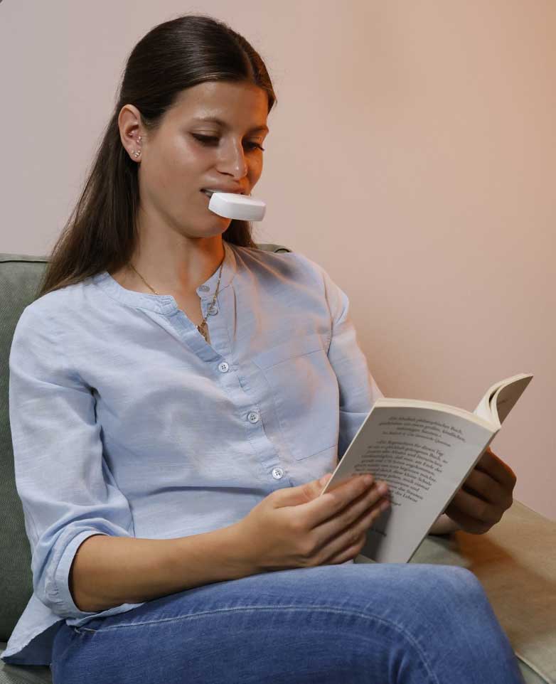 Female patient with OrthoPulse device in mouth