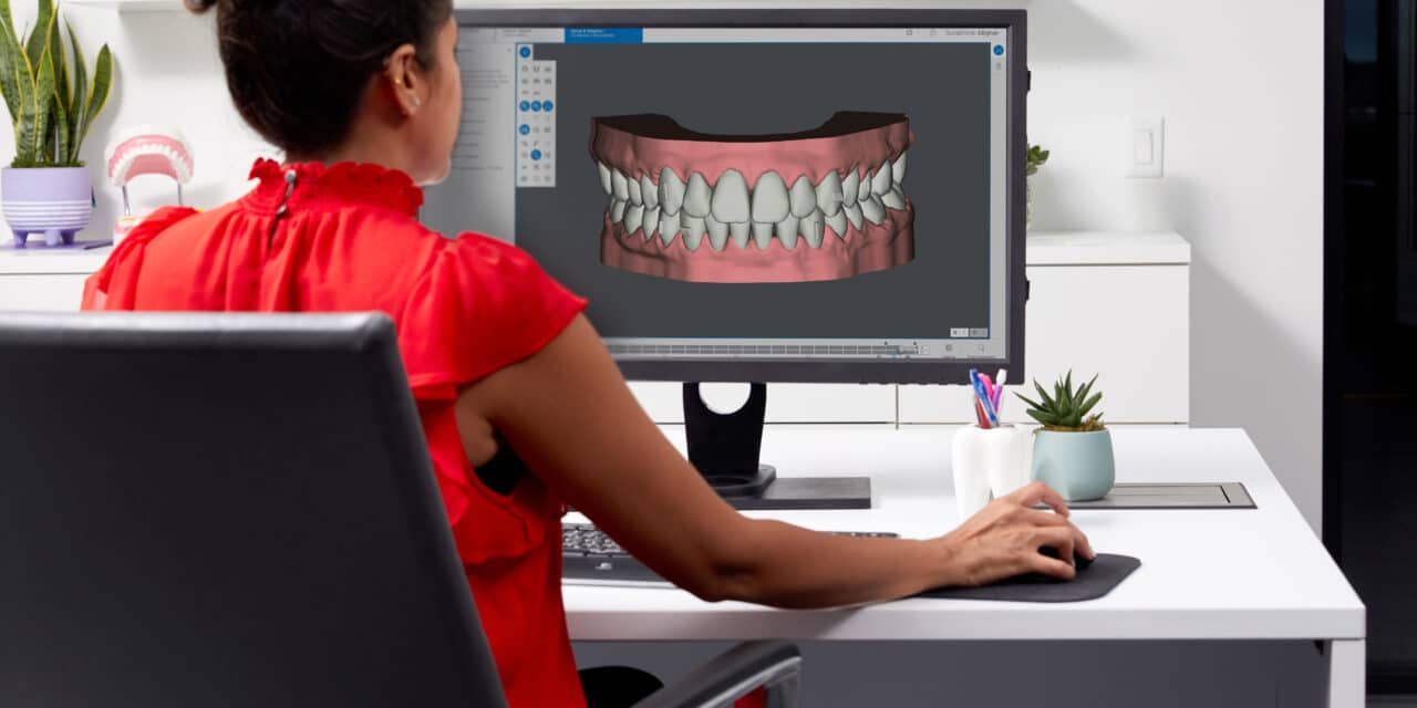 woman sitting at computer that is displaying teeth